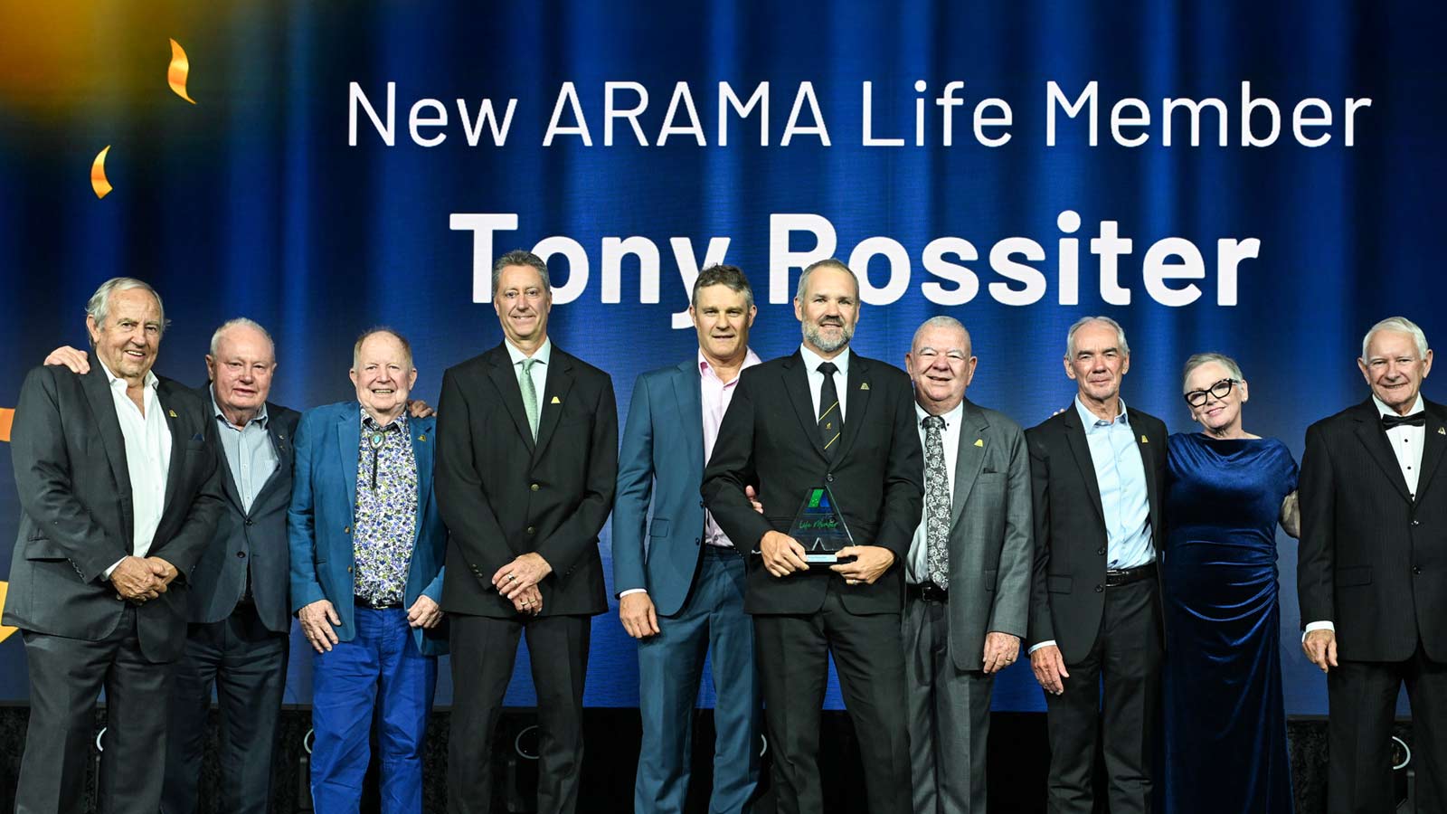 Tony Rossiter receiving his Life Membership Award at the 2025 ARAMA TOP Awards, standing on stage with fellow ARAMA members and industry leaders.